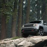 A jeep renegade is parked on the side of a mountain.
