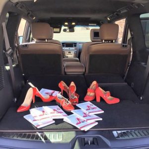 A car trunk with red shoes and a bunch of cards
