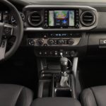 A dashboard of an suv with the center console and infotainment system.
