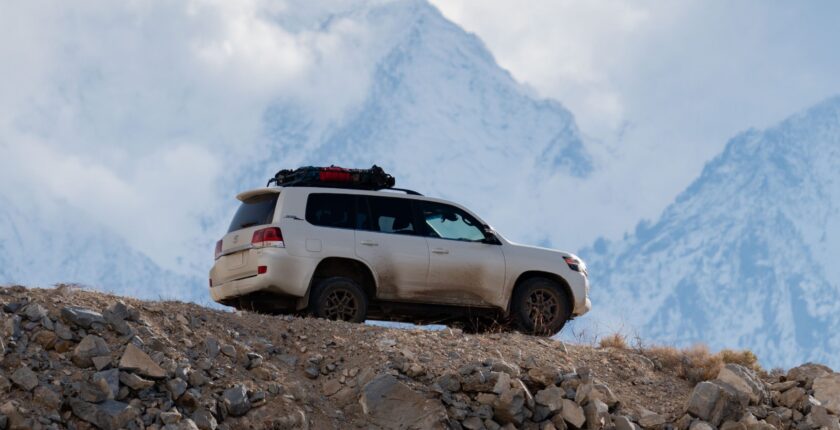 A white suv is parked on the side of a mountain.
