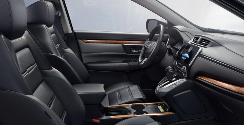 A car with black leather seats and wood trim.
