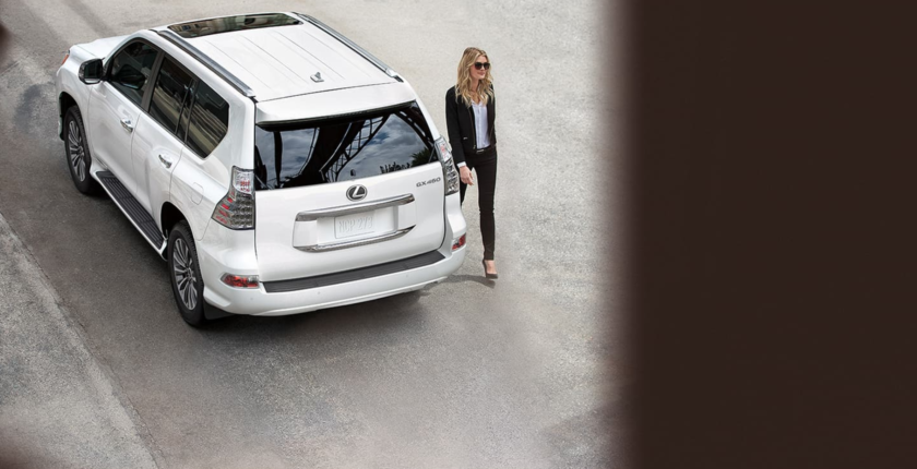 A woman standing next to a white suv.