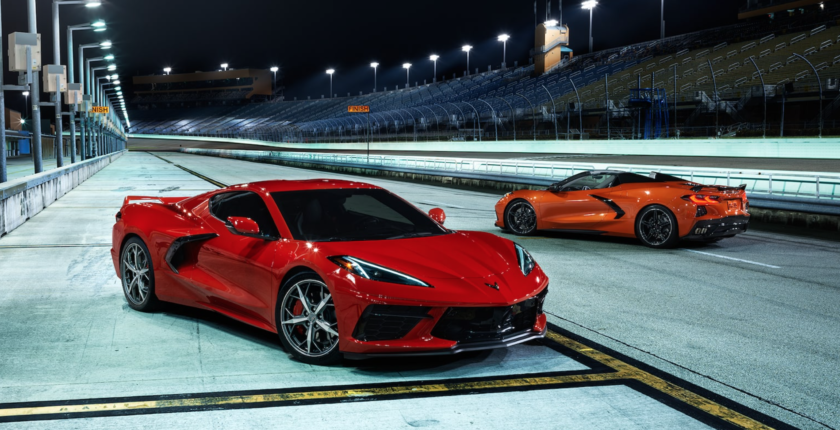 A red sports car and an orange sports car on the track.