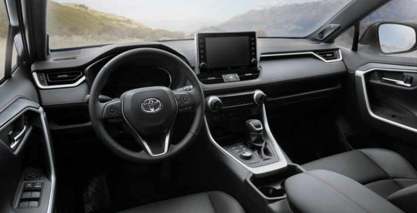 A car dashboard with the steering wheel and infotainment system.