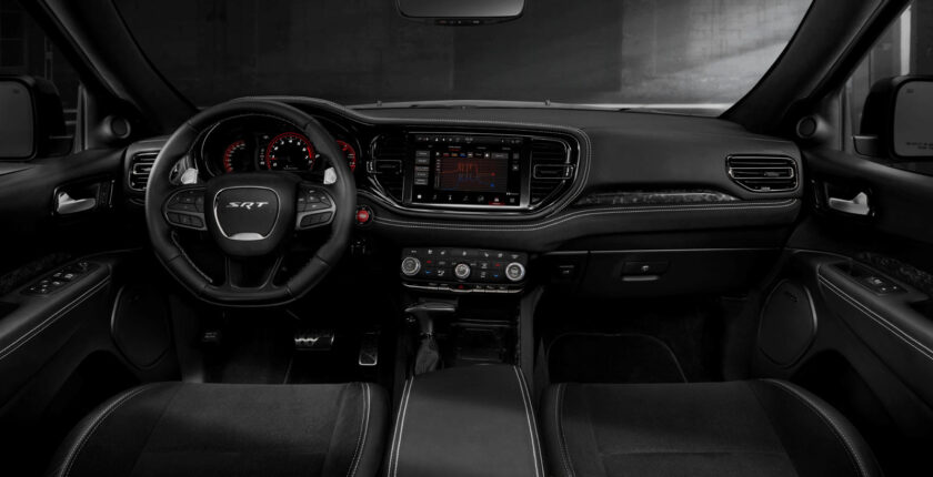 A black car interior with the dashboard and steering wheel.
