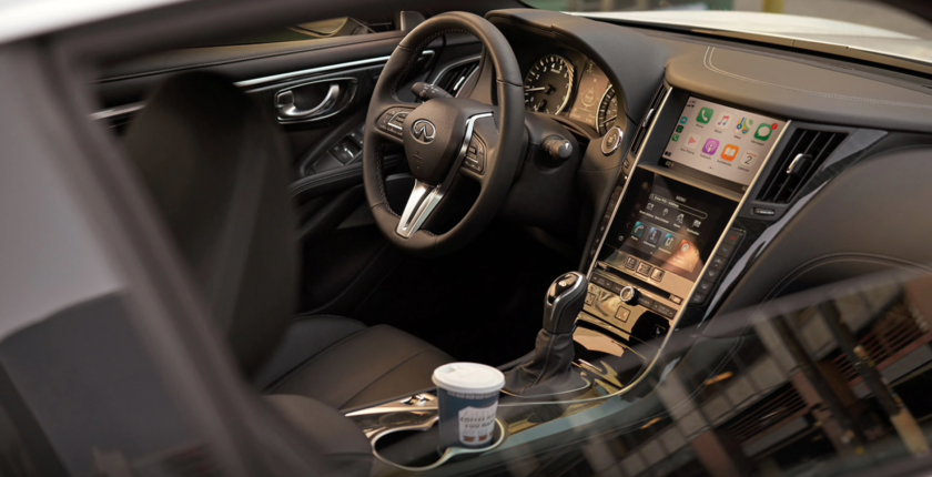 A car interior with the steering wheel and dashboard.