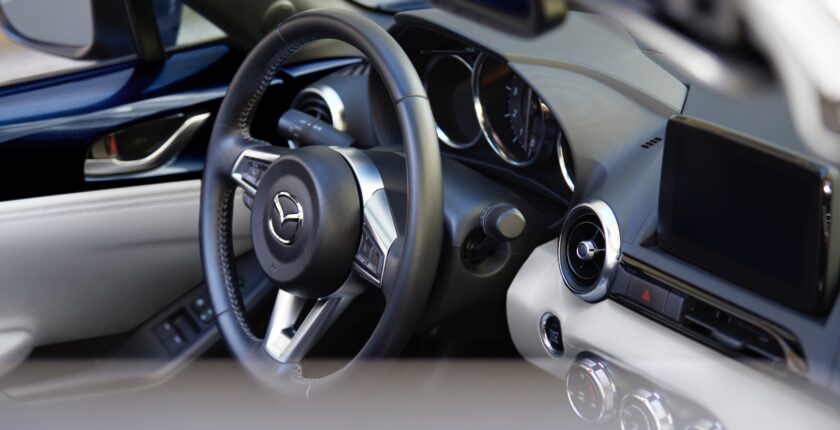 A close up of the steering wheel and dashboard in a car.