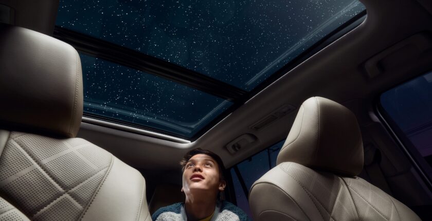 A person in the back of a car looking up at the sky.