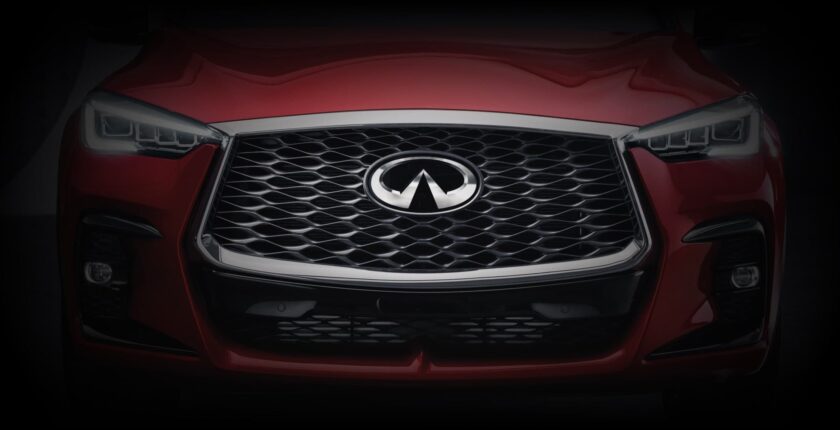 A close up of the front grill on a red infiniti.
