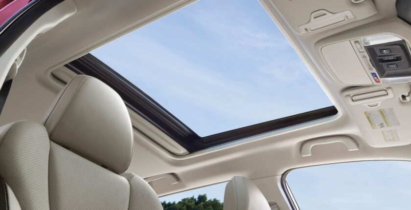 A car with the sun shining in it's sunroof.