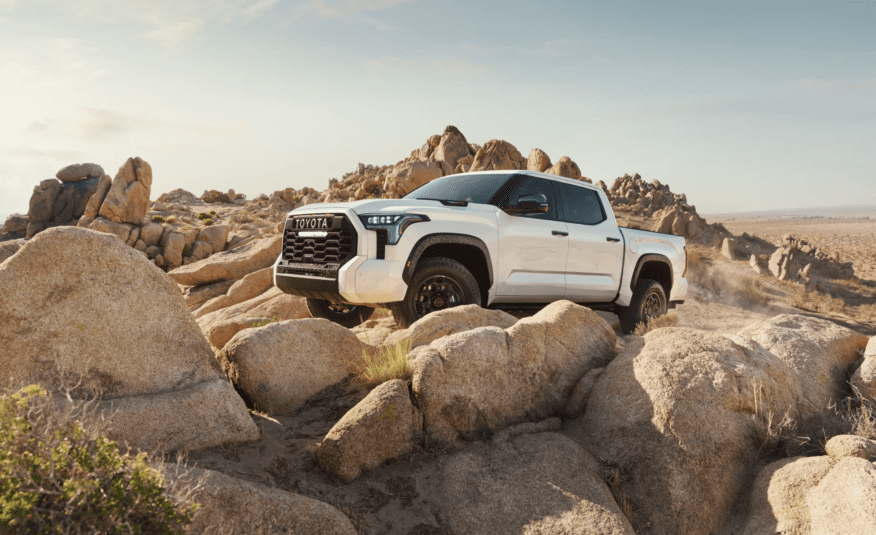 A white truck is parked on some rocks