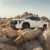 A white truck is parked on some rocks