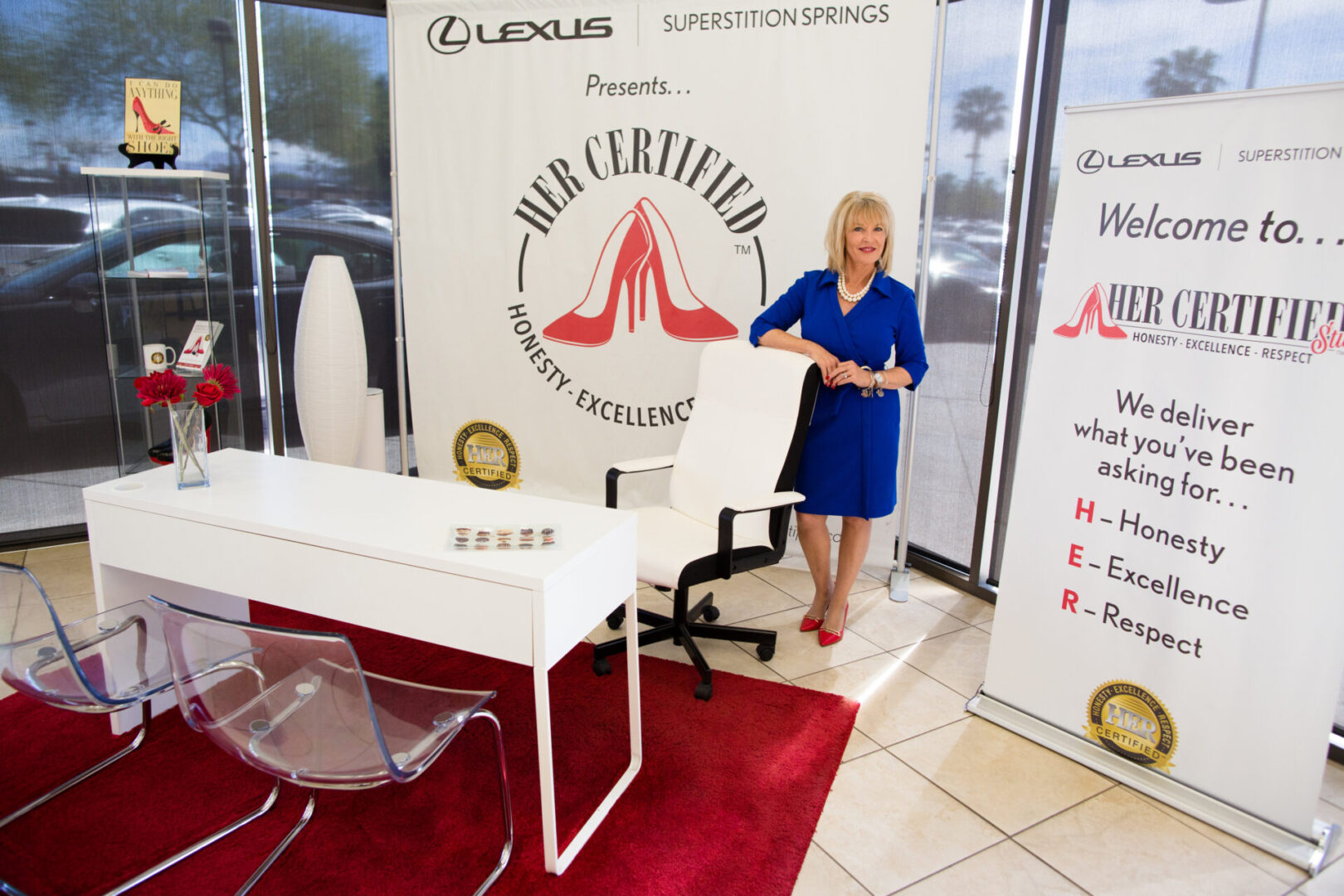 A woman standing in front of a sign that says " our certified professional excellence ".