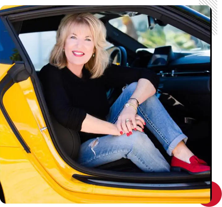 A woman sitting in the passenger seat of a yellow car.