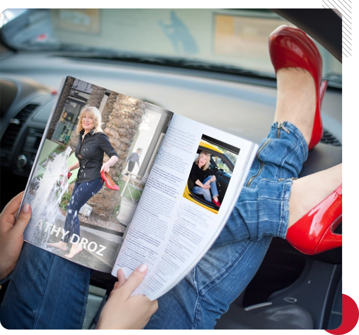 A woman in red shoes reading a magazine.